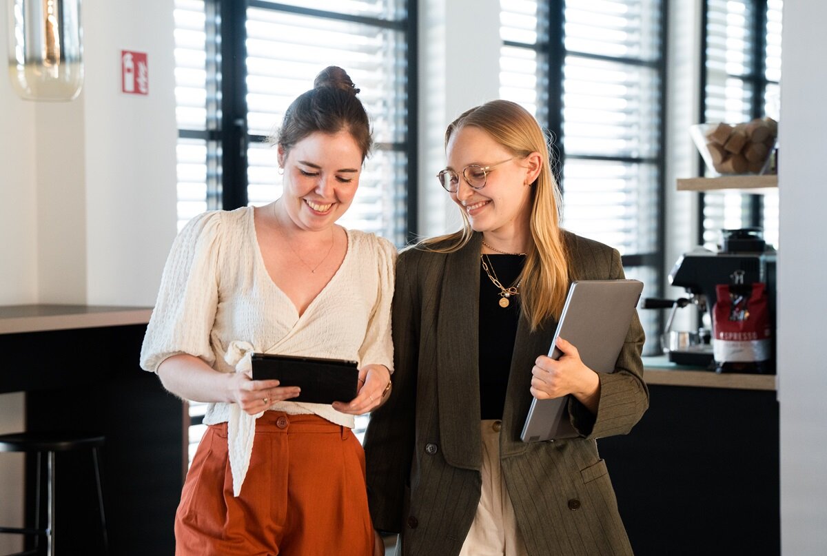 lingoking Mitarbeiterinnen schauen im Gehen auf Tablet
