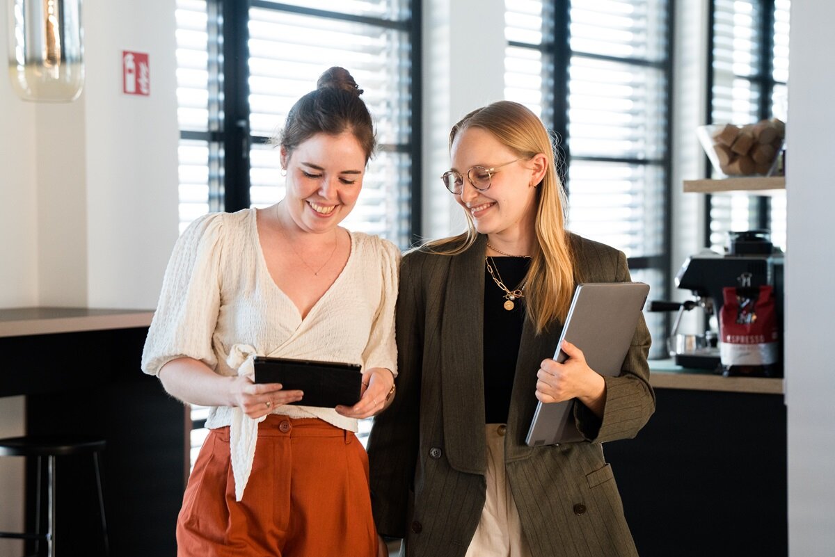 lingoking Mitarbeiterinnen schauen im Gehen auf Tablet