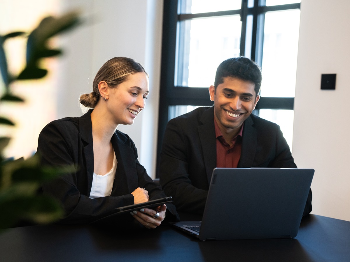 Two people working at laptop