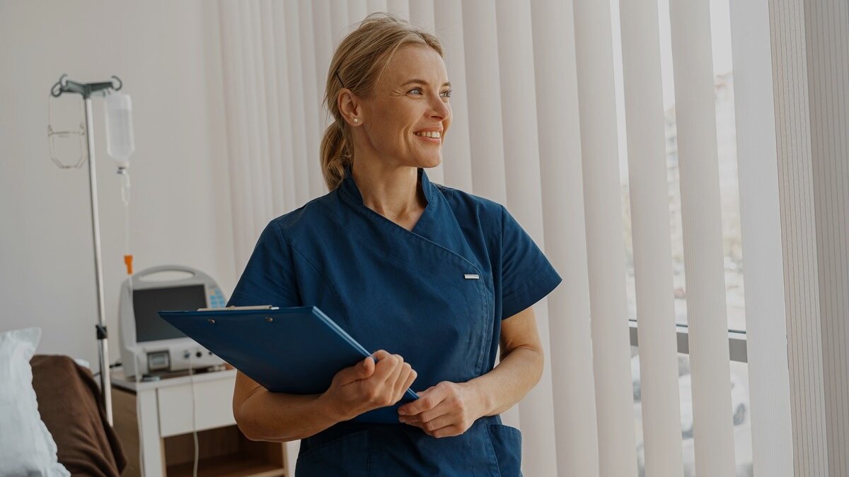 Pflegekraft mit Mappe in Patientenzimmer