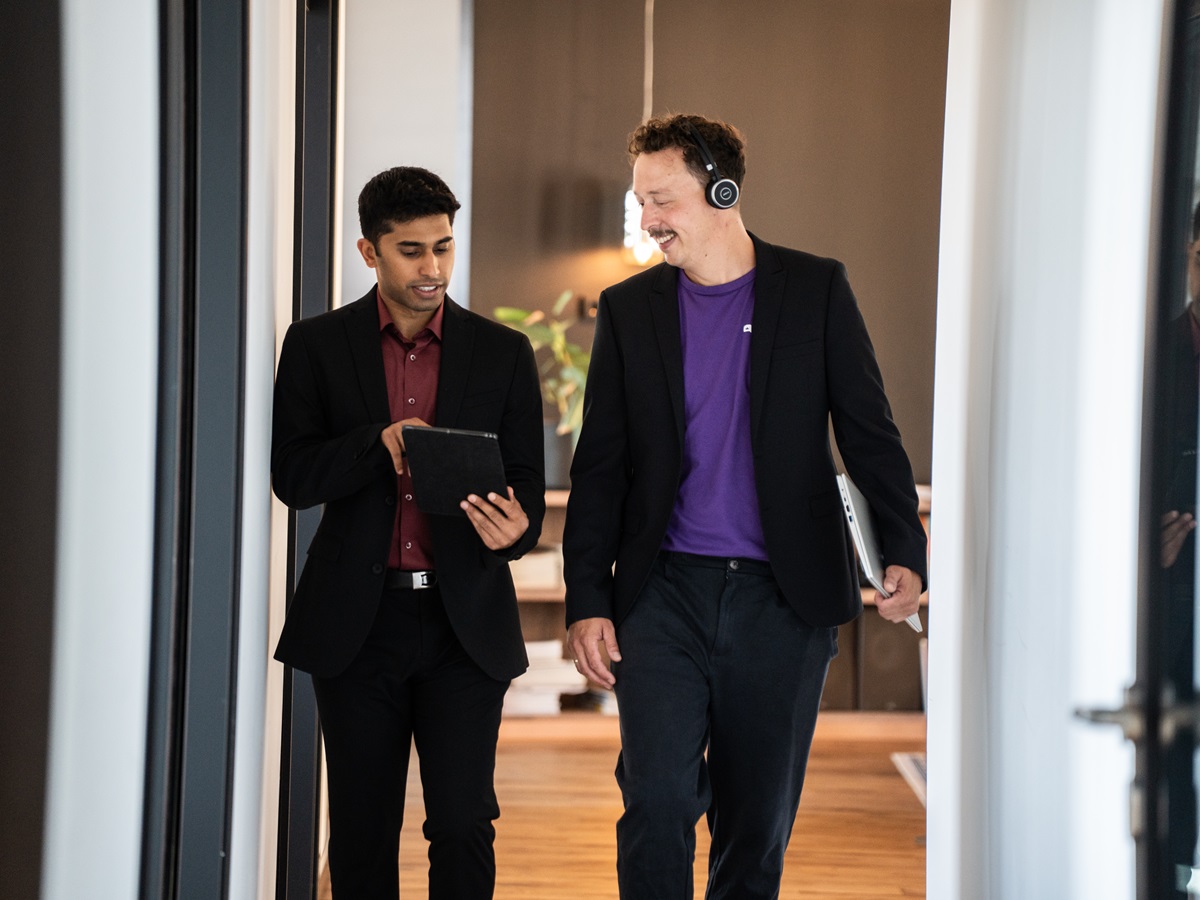 Eine Person zeigt einer anderen etwas auf Tablet