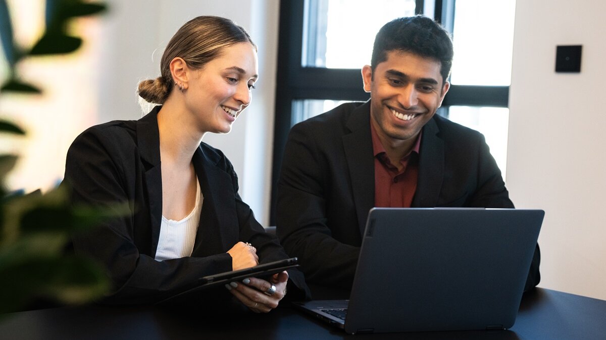 Two people working at laptop