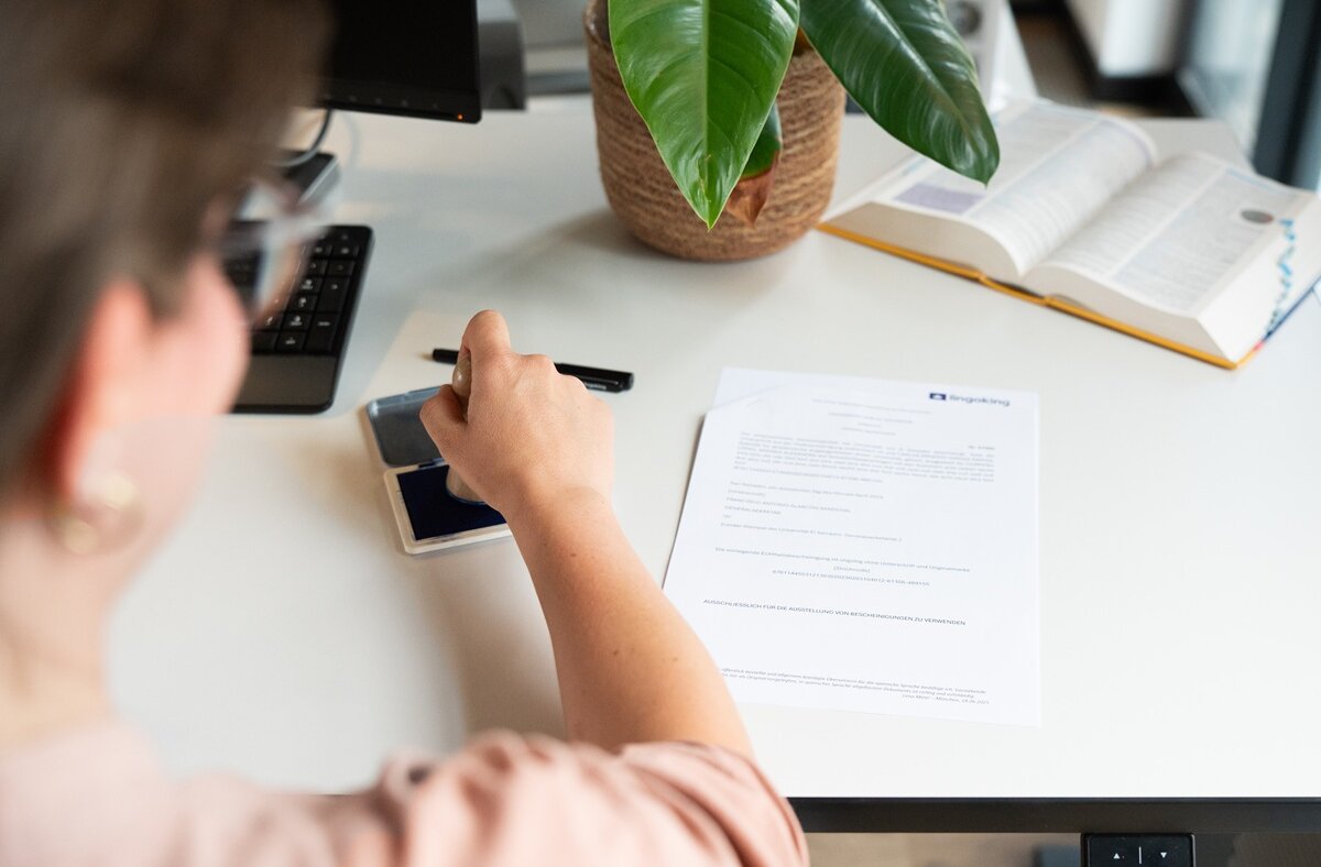 Vereidigte Übersetzerin stempelt Dokument